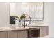 Close-up of a stylish kitchen island with a unique copper sink and faucet, complemented by elegant decor and lighting at 8240 W Tennessee Ave, Lakewood, CO 80226