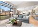 Inviting living room with a comfortable gray sofa, large windows, and an open view to the modern kitchen and outdoor space at 8240 W Tennessee Ave, Lakewood, CO 80226