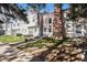 Charming two-story townhome exhibits tidy landscaping, neutral colors, and a brick chimney at 3231 S Estes St, Lakewood, CO 80227
