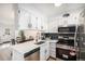 Modern kitchen features stainless steel appliances, white cabinets, and stylish black backsplash at 3231 S Estes St, Lakewood, CO 80227