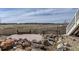 Scenic backyard featuring a stone patio, bridge over a creek, and views of the neighborhood at 12291 Coral Burst Ct, Parker, CO 80134