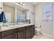 Bright bathroom with a double sink vanity, granite counters, and tropical themed shower curtain at 12291 Coral Burst Ct, Parker, CO 80134