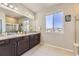 Elegant bathroom offers double sinks, granite countertops, and a walk-in shower with glass doors at 12291 Coral Burst Ct, Parker, CO 80134