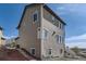Exterior view of a multi-story home featuring neutral siding, multiple windows, and a sloped yard at 12291 Coral Burst Ct, Parker, CO 80134