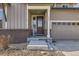 Inviting front entrance with decorative door, covered porch, and attractive landscaping at 12291 Coral Burst Ct, Parker, CO 80134