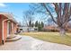 Back patio featuring a stamped concrete patio, brick home, and mature landscaping at 2793 S Stuart St, Denver, CO 80236