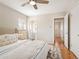 A styled main bedroom with an ensuite bathroom, hardwood floors, geometric rug, and neutral colors at 2793 S Stuart St, Denver, CO 80236