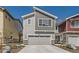New construction exterior featuring a gray horizontal siding and a two-car garage with stone accents at 4327 E 98Th Pl, Thornton, CO 80229
