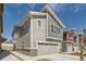 New construction home featuring a two-car garage with stone accents and gray horizontal siding at 4327 E 98Th Pl, Thornton, CO 80229
