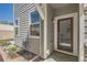 Exterior view of a house with gray siding and a red front door and landscaped yard at 4327 E 98Th Pl, Thornton, CO 80229