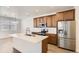 Bright kitchen area features stainless appliances, island with sink, and modern cabinetry at 4327 E 98Th Pl, Thornton, CO 80229