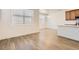 Open-concept living room featuring laminate floors, white walls, and large windows for ample natural light at 4327 E 98Th Pl, Thornton, CO 80229
