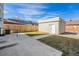 View of the concrete patio and grassy backyard featuring a detached garage with a white door at 2409 W 38Th Ave, Denver, CO 80211