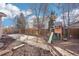 Large fenced backyard featuring a play structure, mature trees, and a well-maintained lawn at 4844 Mt Evans St, Brighton, CO 80601