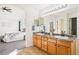 Bathroom with double vanity, modern lighting, and a glimpse into the main bedroom at 4844 Mt Evans St, Brighton, CO 80601