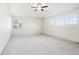 Large, bright, empty bedroom with three large windows, carpet and neutral paint at 4844 Mt Evans St, Brighton, CO 80601