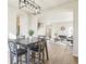 Bright, open concept dining area with modern lighting, flowing into the living room at 4844 Mt Evans St, Brighton, CO 80601