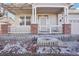 Inviting front porch with brick accents and white railings offers a warm welcome to the charming home at 4844 Mt Evans St, Brighton, CO 80601