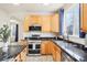 Kitchen with stainless steel appliances, black marbled counters, and wood cabinets at 4844 Mt Evans St, Brighton, CO 80601