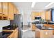Well-lit kitchen with stainless steel appliances, black marbled counters, and wood cabinets at 4844 Mt Evans St, Brighton, CO 80601