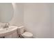 Stylish half bathroom featuring a modern vanity, circular mirror, and updated fixtures at 13729 Daffodil Pt, Parker, CO 80134