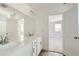 Bright bathroom with dual sinks, white cabinets, and an open doorway to the bedroom at 13729 Daffodil Pt, Parker, CO 80134