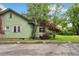 Side view of charming green home with a brick chimney and lush landscaping offering a serene outdoor space at 1900 S University Blvd, Denver, CO 80210