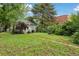 Charming green home with a lush green yard and overgrown garden offering potential for beautiful landscaping at 1900 S University Blvd, Denver, CO 80210