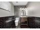 Modern bathroom with a pedestal sink, black brick-style tile, and modern fixtures at 16658 E 106Th Dr, Commerce City, CO 80022