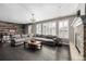 Open living room featuring a large gray sectional sofa, wood accent wall, fire place, and lots of natural light at 16658 E 106Th Dr, Commerce City, CO 80022