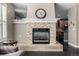 Living room fireplace with stone surround mantel, hardwood floors and opening to the kitchen with breakfast bar seating at 16658 E 106Th Dr, Commerce City, CO 80022