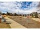 A playground featuring various play structures, a walking path and bench seating surrounded by landscaping at 16658 E 106Th Dr, Commerce City, CO 80022