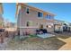 Spacious backyard with a small patio, grill, chairs, and lush green grass at 26881 E Roxbury Pl, Aurora, CO 80016