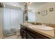 Bright bathroom featuring a double vanity, framed mirror, and patterned shower curtain at 26881 E Roxbury Pl, Aurora, CO 80016
