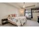 Bright bedroom features a tray ceiling, soft carpet, and a chandelier above the bed at 26881 E Roxbury Pl, Aurora, CO 80016