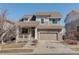 Inviting two-story home featuring a two-car garage and covered porch with brick at 26881 E Roxbury Pl, Aurora, CO 80016