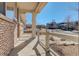 View of the covered front porch featuring brick accents and a view of the neighborhood at 26881 E Roxbury Pl, Aurora, CO 80016