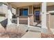 Close-up of the covered front porch with brick accents and a decorative front door at 26881 E Roxbury Pl, Aurora, CO 80016