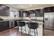 Modern kitchen features dark cabinetry, granite countertops, and stainless steel appliances at 26881 E Roxbury Pl, Aurora, CO 80016