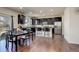 Modern eat-in kitchen features stainless steel appliances, dark cabinetry, and breakfast bar seating at 26881 E Roxbury Pl, Aurora, CO 80016