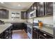 Well-equipped kitchen boasts stainless steel appliances, granite countertops, and sleek dark cabinetry at 26881 E Roxbury Pl, Aurora, CO 80016