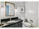 Modern half bathroom with a stylish vanity, dark countertop, and contemporary fixtures at 7873 E Colgate Pl, Denver, CO 80231