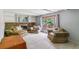 Cozy living room with a brick fireplace, built-in shelves and large windows at 7873 E Colgate Pl, Denver, CO 80231