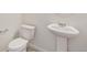 A half bathroom features a pedestal sink and low-flow toilet at 837 Ledge St, Lochbuie, CO 80603