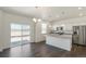 Open concept kitchen with an island, stainless steel appliances, and granite countertops at 837 Ledge St, Lochbuie, CO 80603