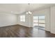 Bright living room with wood floors, a modern chandelier, and sliding glass doors at 837 Ledge St, Lochbuie, CO 80603