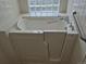 Accessible walk-in bathtub with safety bars and tiled surround provides a secure bathing experience at 11196 E Baltic Dr, Aurora, CO 80014