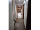 Carpeted hallway leads to unfinished storage with open shelves and lighting at 11196 E Baltic Dr, Aurora, CO 80014