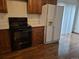 Efficient kitchen layout with black appliances, and wood cabinets at 11196 E Baltic Dr, Aurora, CO 80014