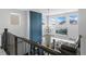 View from the upstairs hallway overlooking the living room, showcasing the chandelier, high ceilings, and windows at 624 Simmental Loop, Castle Rock, CO 80104